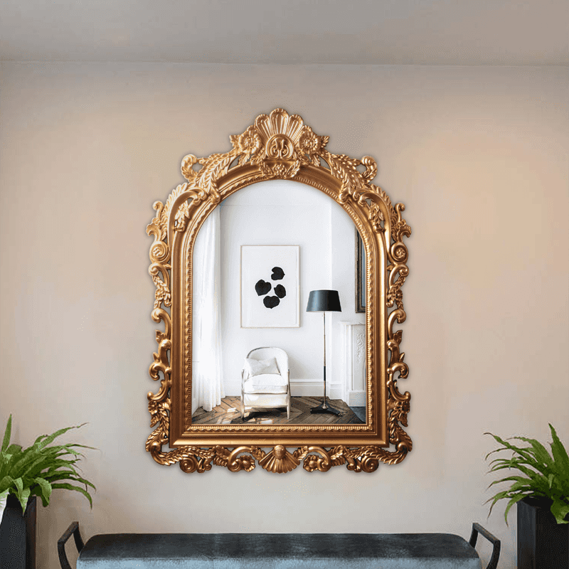 Espejo arqueado de estilo clásico con marco dorado.