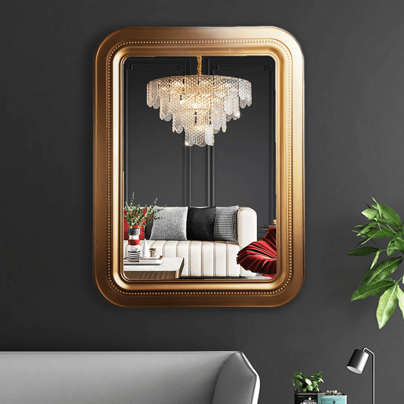 Espejo moderno con marco dorado y esquinas redondeadas.